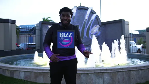 Presenter by a fountain wearing a Timesquare LED chest display showing the Bizz TV logo