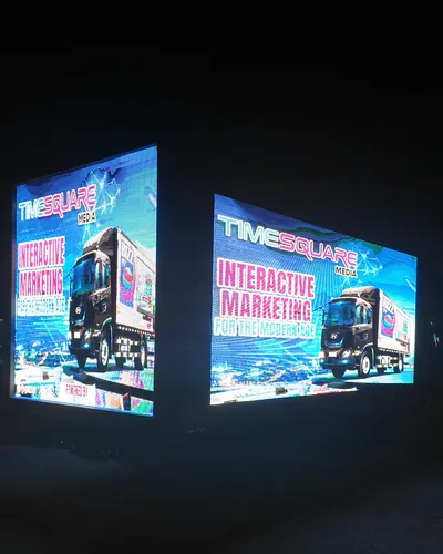 Timesquare LED truck at night with its side and back screens lit, both showing the Timesquare Media Interactive Marketing ad